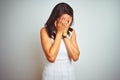 Young beautiful woman wearing dress standing over white isolated background with sad expression covering face with hands while Royalty Free Stock Photo