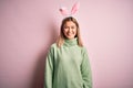 Young beautiful woman wearing easter rabbit ears standing over isolated pink background with a happy and cool smile on face Royalty Free Stock Photo