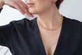 Close up woman wearing elegant gold necklace posing indoors background. Beauty and fashion portrait. Jewellery and Royalty Free Stock Photo