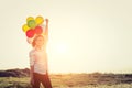 young beautiful woman wearing glasses holding balloons in the field smiley to camera Royalty Free Stock Photo