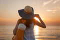 Young and beautiful woman wearing a hat in sunset light looking