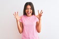 Young beautiful woman wearing pink casual t-shirt standing over isolated white background celebrating mad and crazy for success Royalty Free Stock Photo