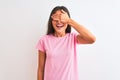 Young beautiful woman wearing pink casual t-shirt standing over isolated white background smiling and laughing with hand on face Royalty Free Stock Photo