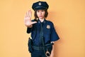 Young beautiful woman wearing police uniform doing stop sing with palm of the hand Royalty Free Stock Photo