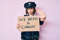 Young beautiful woman wearing police uniform holding we need a change banner with open hand doing stop sign with serious and Royalty Free Stock Photo