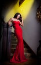 Young beautiful woman wearing a red dress in the old hotel Royalty Free Stock Photo