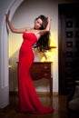 Young beautiful woman wearing a red dress in the old vintage hotel Royalty Free Stock Photo
