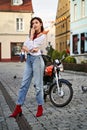 Young beautiful woman in red knitted fabric block heel sock shoes, blue denim jeans pants and teddy jacket coat posing Royalty Free Stock Photo