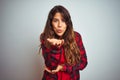 Young beautiful woman wearing red t-shirt and jacket standing over white isolated background looking at the camera blowing a kiss Royalty Free Stock Photo