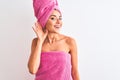 Young beautiful woman wearing shower towel after bath over isolated white background smiling with hand over ear listening an Royalty Free Stock Photo