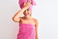 Young beautiful woman wearing shower towel after bath over isolated white background surprised with hand on head for mistake, Royalty Free Stock Photo