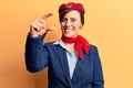 Young beautiful woman wearing stewardess uniform smiling and confident gesturing with hand doing small size sign with fingers