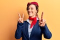 Young beautiful woman wearing stewardess uniform smiling looking to the camera showing fingers doing victory sign Royalty Free Stock Photo