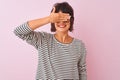 Young beautiful woman wearing striped t-shirt and glasses over isolated pink background smiling and laughing with hand on face Royalty Free Stock Photo