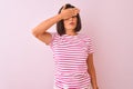 Young beautiful woman wearing striped t-shirt standing over isolated pink background covering eyes with hand, looking serious and Royalty Free Stock Photo