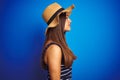 Young beautiful woman wearing striped t-shirt and summer hat over isolated blue background looking to side, relax profile pose Royalty Free Stock Photo