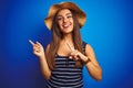 Young beautiful woman wearing striped t-shirt and summer hat over isolated blue background smiling and looking at the camera Royalty Free Stock Photo