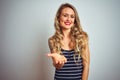 Young beautiful woman wearing stripes t-shirt standing over white isolated background smiling cheerful offering palm hand giving Royalty Free Stock Photo