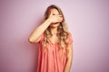 Young beautiful woman wearing t-shirt standing over pink isolated background covering eyes with hand, looking serious and sad Royalty Free Stock Photo