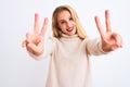 Young beautiful woman wearing turtleneck sweater standing over isolated white background smiling looking to the camera showing Royalty Free Stock Photo