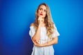 Young beautiful woman wearing white dress standing over blue isolated background with hand on chin thinking about question, Royalty Free Stock Photo