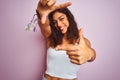 Young beautiful woman wearing white t-shirt standing over isolated pink background smiling making frame with hands and fingers Royalty Free Stock Photo