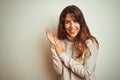 Young beautiful woman wearing winter sweater standing over white isolated background clapping and applauding happy and joyful, Royalty Free Stock Photo