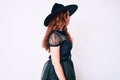 Young beautiful woman wearing witch halloween costume looking to side, relax profile pose with natural face and confident smile