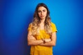 Young beautiful woman wearing yellow t-shirt over blue isolated background skeptic and nervous, disapproving expression on face Royalty Free Stock Photo