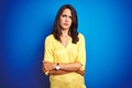 Young beautiful woman wearing yellow t-shirt standing over blue isolated background skeptic and nervous, disapproving expression Royalty Free Stock Photo