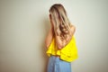 Young beautiful woman wearing yellow t-shirt standing over white isolated background with sad expression covering face with hands Royalty Free Stock Photo