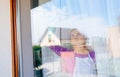 Young beautiful woman in white apron cleaing windows.