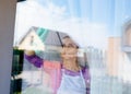 Young beautiful woman in white apron cleaing windows.