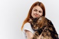 Young beautiful woman on white background holds a cat, pets, emotions Royalty Free Stock Photo