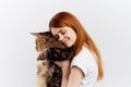 Young beautiful woman on a white background holds a cat, smile, pets Royalty Free Stock Photo