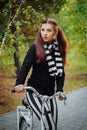 Young, beautiful woman with a white bike, evening in the autumn park. Royalty Free Stock Photo