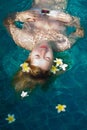 Young beautiful woman in white bikini relaxing in a pool Royalty Free Stock Photo