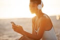 Woman in Bikini with a Smartphone and Headphones on the Beach Royalty Free Stock Photo