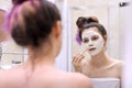 Young beautiful woman with white cosmetic natural healing mask on face