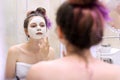 Young beautiful woman with white cosmetic natural healing mask on face