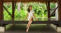 Young and beautiful woman in white dress. Woman posing in exotic Thai bungalow. Resting and traveling concept. Royalty Free Stock Photo