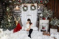 Young and beautiful woman in white knitted sweater and stockings posing in Christmas interior. Modish brunette model Royalty Free Stock Photo