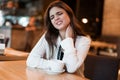 Young beautiful woman in white stylish blouse suffering from pain in neck after hard workday drinking coffee in cafe modern Royalty Free Stock Photo