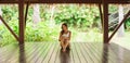 Young and beautiful woman in white swimsuit. Woman posing in exotic Thai bungalow. Resting and traveling concept.