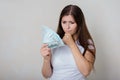 Young, beautiful woman in a white t-shirt with money in her hands  on a white background. Royalty Free Stock Photo