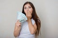 Young, beautiful woman in a white t-shirt with money in her hands  on a white background. Royalty Free Stock Photo