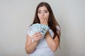 Young, beautiful woman in a white t-shirt with money in her hands  on a white background. Royalty Free Stock Photo