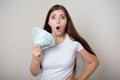 Young, beautiful woman in a white t-shirt with money in her hands  on a white background. Royalty Free Stock Photo