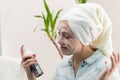 A young beautiful woman with a white towel on her head in the bathroom applied makeup remover to her face against the background o Royalty Free Stock Photo