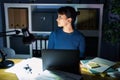 Young beautiful woman working at the office at night looking to side, relax profile pose with natural face with confident smile Royalty Free Stock Photo